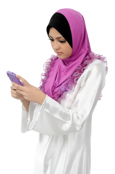 Красивая молодая мусульманка сообщения на мобильном телефоне изолированы на белом фоне — стоковое фото