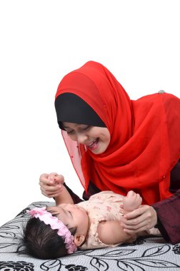 oynama ve beyaz arka plan üzerinde izole şirin bebek kızı ile gülümseyen genç Asyalı Müslüman anne