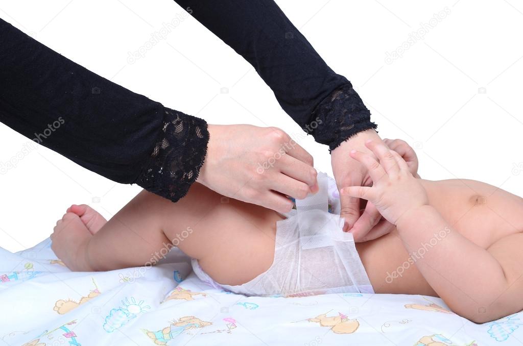 Young muslim mother changing the diaper of her baby isolated on white background