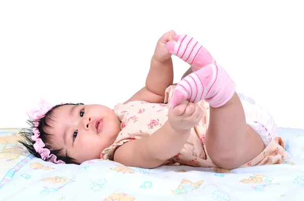 Happy Asian cute baby girl playing with her feet isolated on white background — Stock Photo, Image