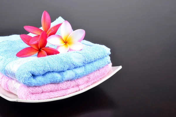Beautiful frangipani flower with folding towels on plate — Stock Photo, Image