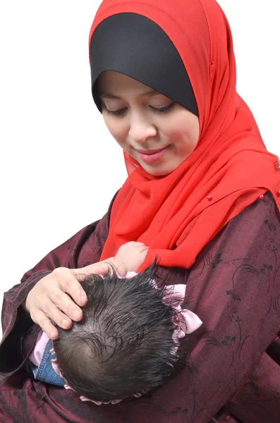 若いアジアのイスラム教徒の母親の母乳白い背景上に分離されて彼女のかわいい赤ちゃんの少女 ロイヤリティフリーのストック画像