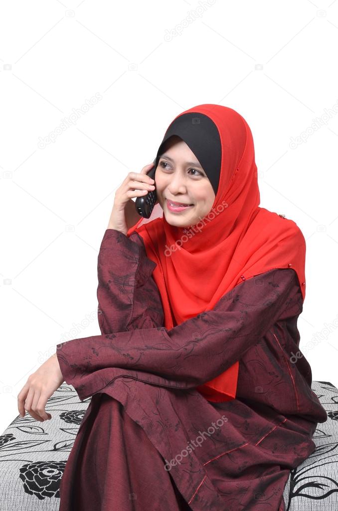 Beautiful young muslim woman happy talking on mobile phone isolated on white background