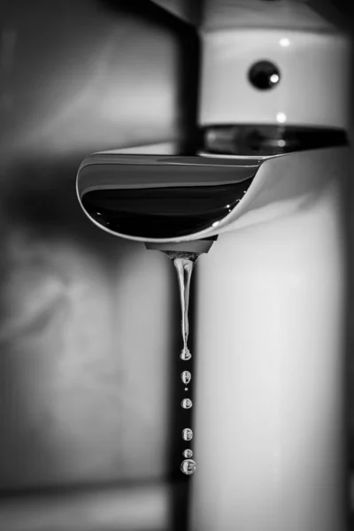 Clear water drops falling from the faucet. Contrast black and white photography. — Stock Photo, Image