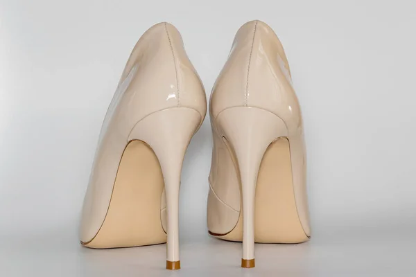Achteraanzicht van de naakt beige gekleurde hoge hakken damesschoenen. — Stockfoto