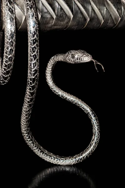 Vertical closeup photo of snake made from silver.