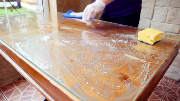 Uma mesa de madeira em um café é lavada com uma esponja e detergente. limpeza de molas — Vídeo de Stock