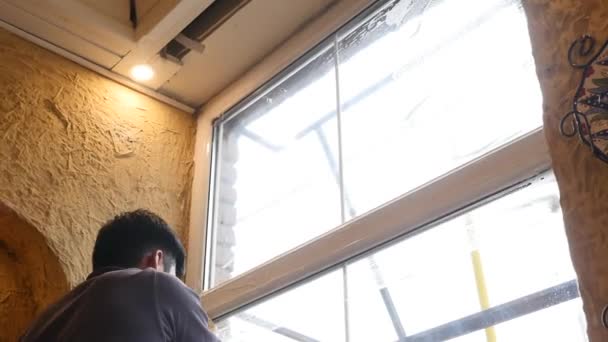 Azjatycki sprzątacz myje okna pianką, czyści szkło — Wideo stockowe