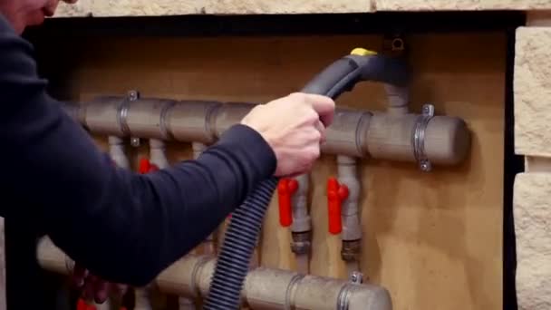 Ev temizliği. Adam kanalizasyon borularını ve radyatörü süpürüyor. yakın çekim temizleyici — Stok video