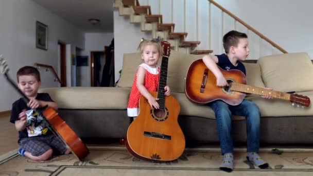 Niños aprenden a tocar la guitarra clásica. Grupo de niños pequeños tocando música — Vídeo de stock