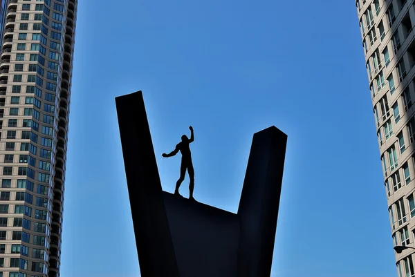 A silhueta preta de um acrobata que se equilibra em um pedestal — Fotografia de Stock