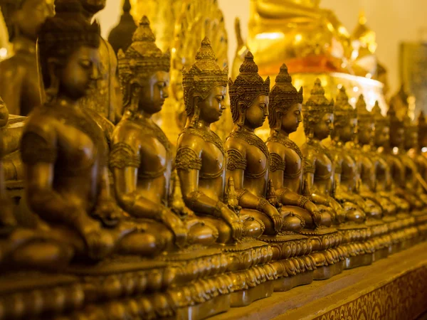 Rij van de boeddhabeelden achter boeddhistische tempel — Stockfoto