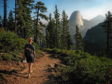 Hiker Walking on Trail with Half Dome in the Background clipart