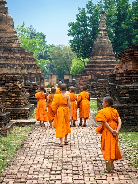 Beginner boeddhistische monniken, wandelen onder ruïnes in sukhothai, thailand — Stockfoto