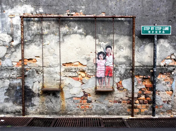 Niños en el columpio Pieza de arte de la calle en Georgetown, Penang, Ma —  Fotos de Stock