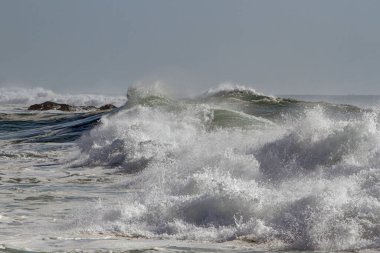 Kuzey Portekiz sahillerinde dalgalar kopuyor dalgalı bir denizde ama güneşli bir günde..
