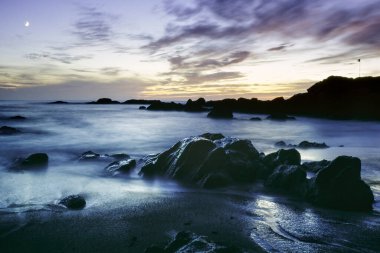 Uzun pozlama kayalık deniz manzarası alacakaranlıkta. Analog: 35 mm slayt film.