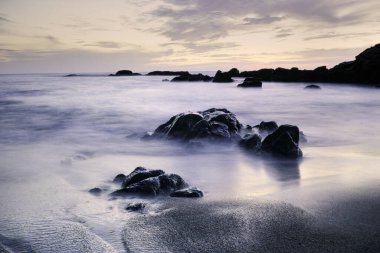 Uzun pozlama kayalık deniz manzarası alacakaranlıkta. Analog: 35 mm slayt film.