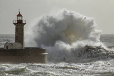 Büyük fırtınalı dalga sıçraması. Douro Nehri ağzının eski feneri, Porto, Portekiz.