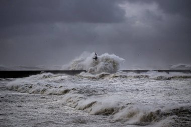 Fırtınalı dalga, Douro nehrinin ağzında kara bulutlu gökyüzüne sıçrıyor, Porto, Portekiz