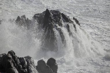 Büyük bir dalga tarafından vurulduktan sonra deniz uçurumu. Kuzey Portekiz kayalık kıyıları.