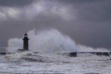 Fırtınalı dalga, Douro nehrinin ağzında kara bulutlu gökyüzüne sıçrıyor, Porto, Portekiz