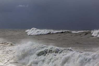 Mavi yağmurlu gökyüzüne karşı dalgalı denizle kışın deniz manzarası