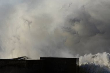 Fırtınalı büyük dalgalar bir iskeleye çarpıyor..