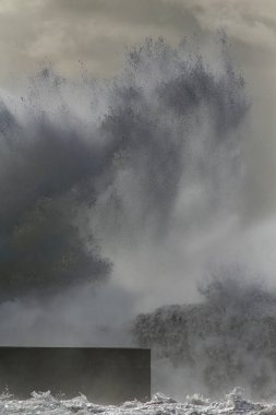 Büyük fırtınalı dalgalar sıçradı ve püskürtüldü. Nemle filtrelenmiş ilginç bir ışık.