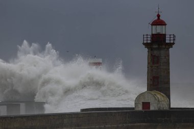 Büyük fırtınalı deniz dalgası sıçraması. Douro nehri ağzı güney rıhtımları ve deniz fenerleri.