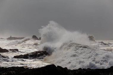 Dalga sıçraması. Fırtına sırasında kuzey Portekiz kayalık kıyıları.