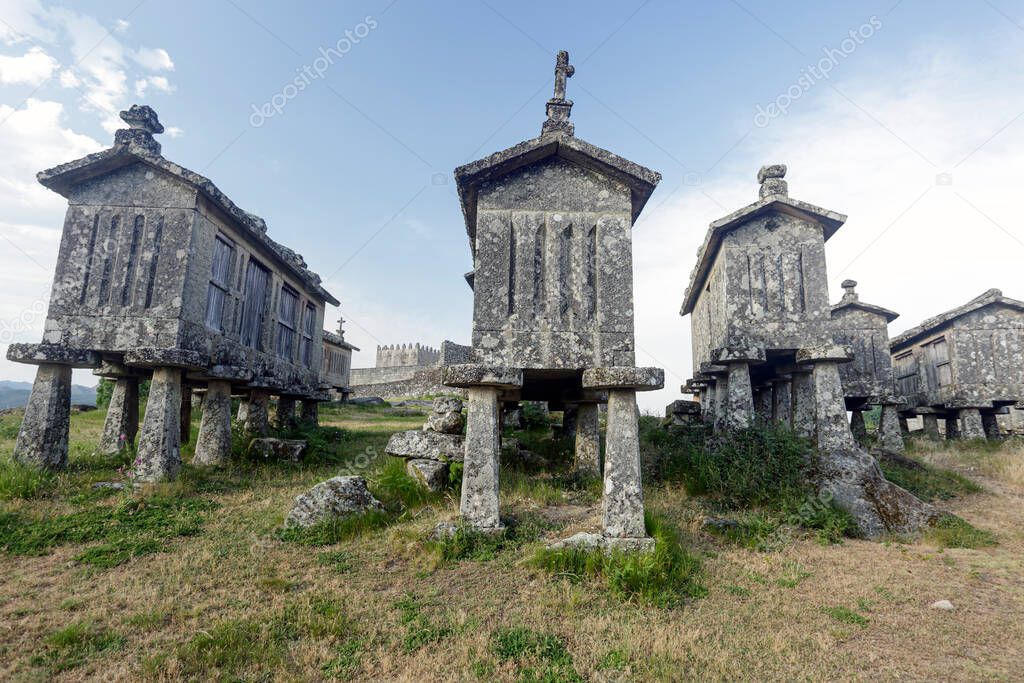Old stone granaries and medieval castle, Lindoso, north of Portugal.