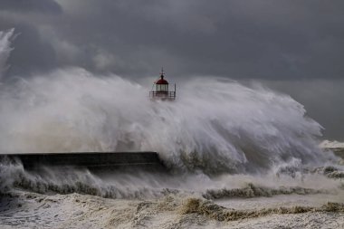 Huge stormy wave splash over Douro river mouth old lighthouse, Porto, Portugal.