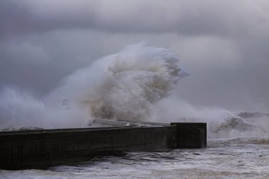 Büyük dalga sıçraması. Bulutlu bir günde. Douro Nehri Ağzı, Porto, Portekiz.