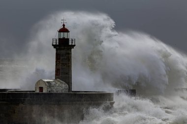 Huge stormy wave splash. Douro river mouth old lighthouse and granite pier, Porto, Portugal.