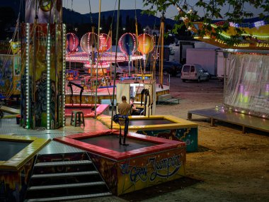 Ponte de Lima, Portekiz - 9 Eylül 2022: Akşam yemeği sırasında eğlence parkı boş, iki eğlence sahibinin müşteri beklediğini görüyoruz. Feiras Novas Festivali (Yeni Fuarlar)).