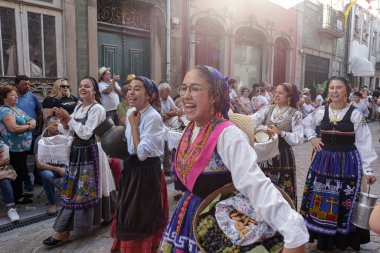 Ponte de Lima - 10 Eylül 2022: Portekiz 'in kuzeyindeki Feiras Novas şenliklerinde geleneksel kostümleri giyen gençler.