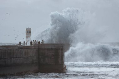 Porto, Portekiz - 31 Aralık 2015: Douro Nehri ağzında fırtınayı izleyen insanlar yeni iskele ve fener.