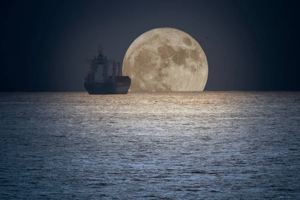 Εμπορικό Πλοίο Στον Ορίζοντα Μια Νύχτα Πανσελήνου — Φωτογραφία Αρχείου