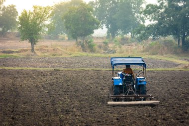 TIKAMGARH, MADHYA PRADESH, INDIA - MAY 02, 2022: Indian farmer working with tractor in agriculture field.