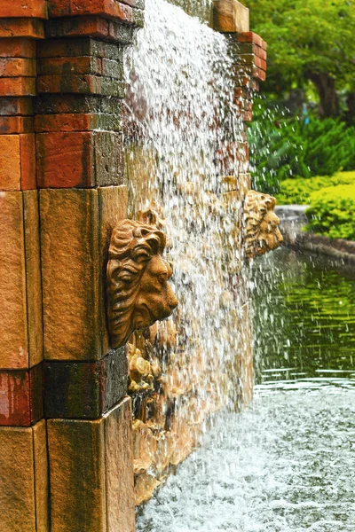 Waterfall in the garden - a lion's head statue. — Stock Photo, Image