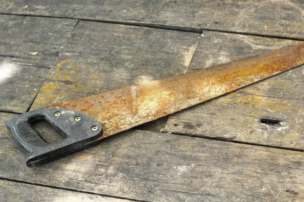 Old rusty saw on the wooden background — Stock Photo, Image