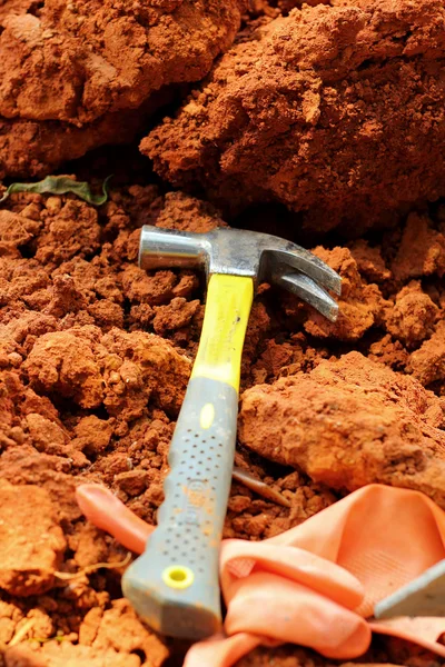 Martillo con guantes de goma anaranjados en el suelo . — Foto de Stock