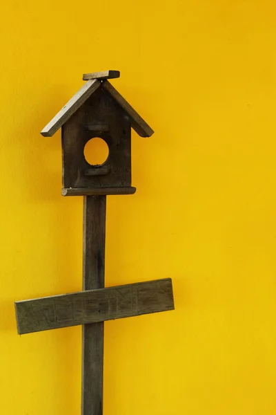 Wooden bird house with yellow wall — Stock Photo, Image