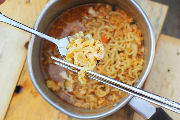 Chopsticks holding asian noodles in pot — Stock Photo, Image