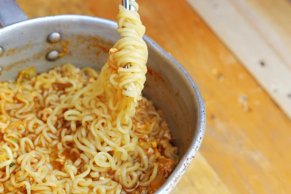 Chopsticks holding asian noodles in pot Stock Picture