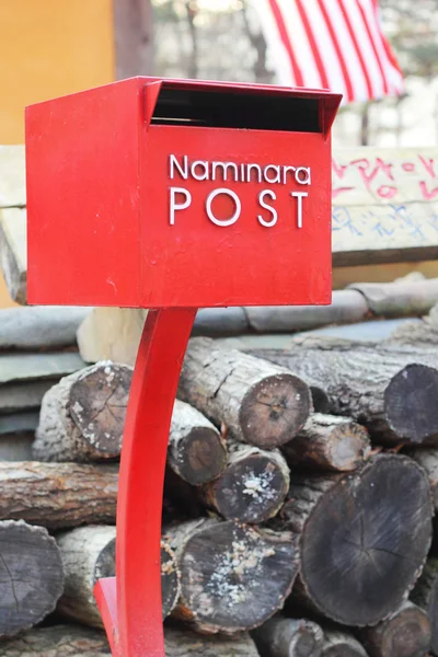 木の杭を持つ赤い郵便ポスト. — ストック写真