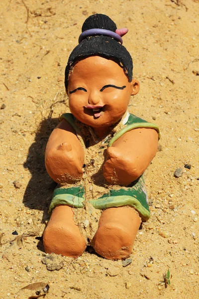 Baby Doll statue on the sand. — Stock Photo, Image