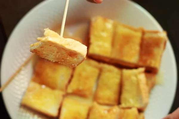 Children eat bread, butter, and milk in a dish. — Stock Photo, Image