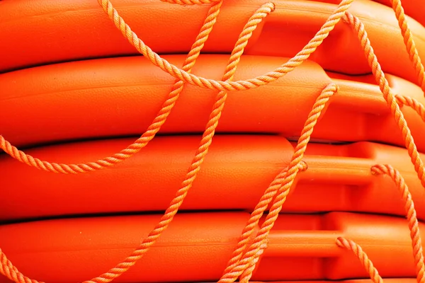 Stacked orange rescue round buoy, sea marine lifesaver — Stock Photo, Image